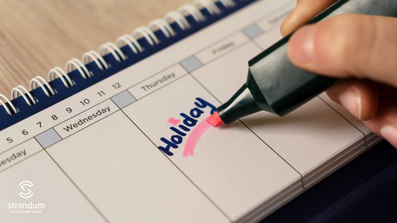 Employee marking holiday dates on a calendar.